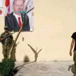 Cerablus'ta bir ÖSO üyesi, Erdoğan'ın posteri önünde fotoğraf çektiriyor.